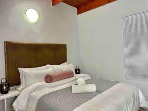 1 dormitorio con 1 cama grande y cabecero marrón en Separate entry cozy Guesthouse en Hillcrest