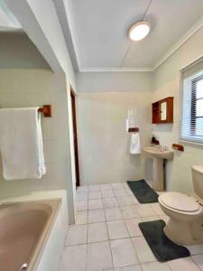 y baño con bañera, aseo y lavamanos. en Separate entry cozy Guesthouse en Hillcrest
