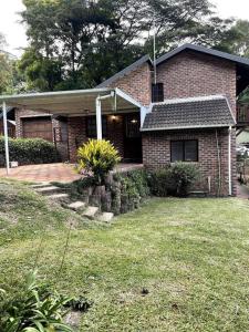 ein Backsteinhaus mit einem Rasen davor in der Unterkunft Separate entry cozy Guesthouse in Hillcrest