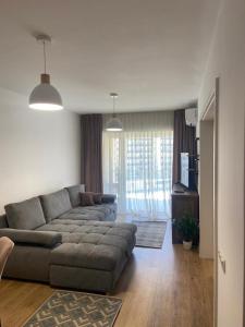 a living room with a gray couch and a living room with at Dora City Apartament in Cluj-Napoca