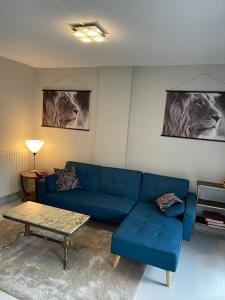 een woonkamer met een blauwe bank en een tafel bij A 2 pas de la gare in Chalon-sur-Saône