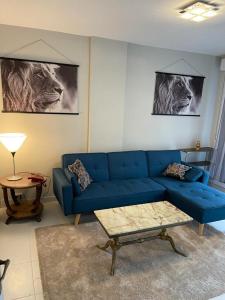 a living room with a blue couch and a table at A 2 pas de la gare in Chalon-sur-Saône