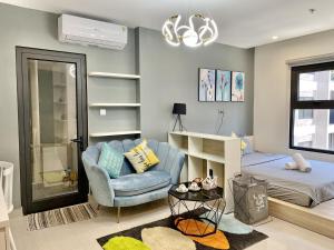 a bedroom with a blue chair and a bed at VINHOME OCEAN PARK GIA LÂM in Hanoi