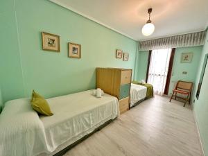 a bedroom with two beds and a dresser in it at Apartamentos La Caseta in Isla