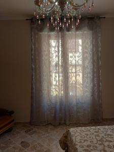 - une chambre avec une fenêtre et un lustre dans l'établissement Borgo Saraceno Primo, à Sambuca di Sicilia