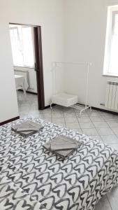 Chambre blanche avec tapis noir et blanc au sol dans l'établissement Appartamento a Lecco sul Lago di Como, à Lecco