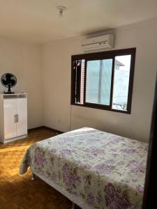 a bedroom with a bed and a window at Apto familiar em Cachoeirinha-RS in Cachoeirinha