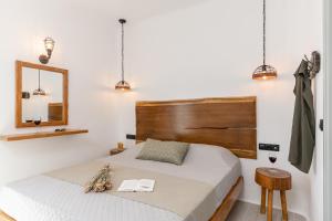 sypialnia z łóżkiem z drewnianym zagłówkiem i lustrem w obiekcie Sunshine Plaka Naxos w mieście Plaka