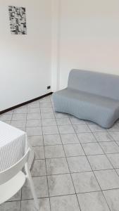 - une chambre avec un lit, une chaise et du carrelage dans l'établissement Appartamento a Lecco sul Lago di Como, à Lecco