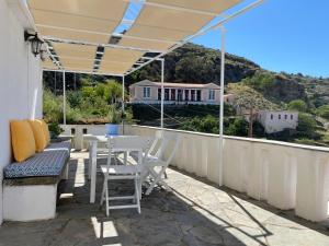 eine Terrasse mit einem Tisch und Stühlen auf dem Balkon in der Unterkunft The Great Balcony in Ioulis