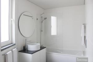 a white bathroom with a sink and a mirror at Azores Essence - Coliseu in Ponta Delgada