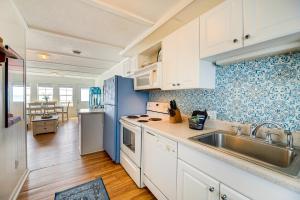 a kitchen with white cabinets and a stainless steel sink at Beachfront Emerald Isle Vacation Rental with Deck! in Emerald Isle