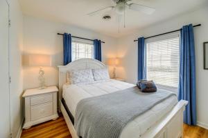 a bedroom with a white bed and blue curtains at Beachfront Emerald Isle Vacation Rental with Deck! in Emerald Isle