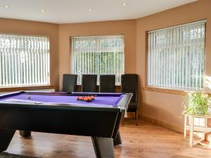 a pool table in a room with windows at Home Farm - Farmhouse in Dunragit
