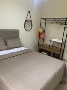 a bedroom with a bed and a mirror on the wall at Além do Horizonte in Itanhaém