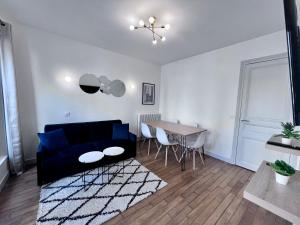 a living room with a blue couch and a table at Paris 18 - 6P - 2BR - Appartement cosy moderne équipé in Paris