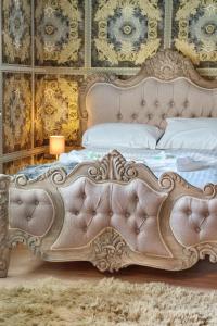 an ornate bed in a bedroom with a white bed frame at Cinema & Games Room Pool Table, Hot Tub, Sleeps 15 in Saffron Walden