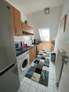 a kitchen with a washing machine and a rug on the floor at Dachgeschoss Apartment mit Ausblick in Halle an der Saale