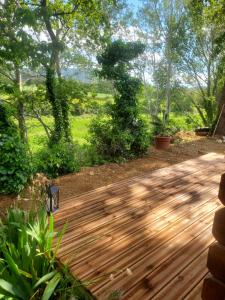 a wooden deck with trees in the background at Escale Détente en amoureux Spa en option in Allan