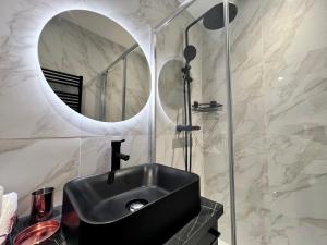 a bathroom with a black sink and a mirror at Paris 18 - 6P - 2BR - Appartement cosy moderne équipé in Paris