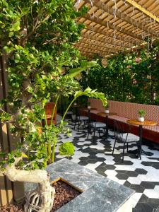 a patio with tables and chairs and a tree at Wolf Suites in Antalya