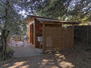 een houten schuur met een wastafel en een boom bij Yurta Agricamping Villamagra in Santa Luce