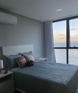 - une chambre avec un lit et une vue sur l'océan dans l'établissement Apartamento no 20º andar Barra Home Stay, à Récife