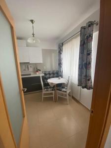 a kitchen with a table and chairs and a table and a kitchen at Dora City Apartament in Cluj-Napoca