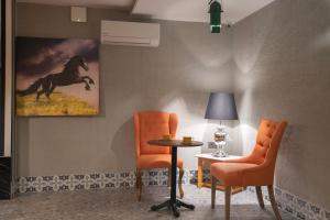 a room with two chairs and a table and a picture of a horse at Wolf Suites in Antalya