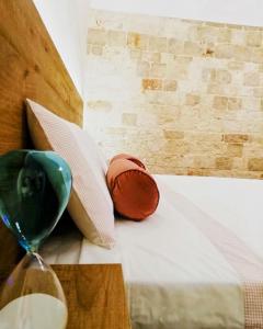 - un verre de vin assis au-dessus du lit dans l'établissement Antiche Mura Apartments"Bianco di Puglia" cucina 1 camera da letto più divano letto, à Turi