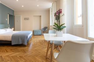 een hotelkamer met een bed en een tafel en stoelen bij Aqualago casa vacanze apartment D in Verbania