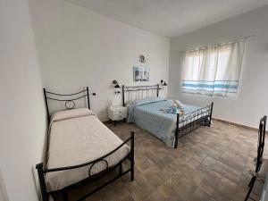 a bedroom with two beds and a window at Casa vacanze Mare Fuori in Capoterra +46 photos
