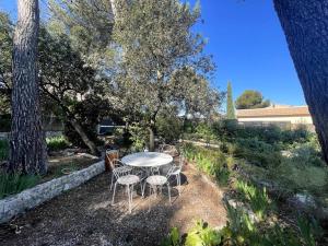 a white table and chairs in a yard at Villa Terres Blanches à 10 min d'Aix-en-Provence in Bouc-Bel-Air