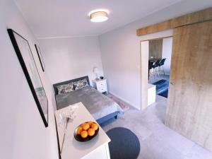 a bedroom with a bed and a table with oranges on it at Lulu Apartments - Apartament FRIDA blisko morza - Resort Kołobrzeg parking i basen z sauną w cenie in Kołobrzeg