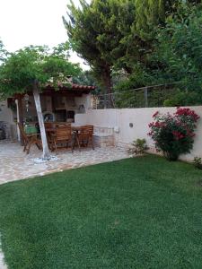 a patio with a table and chairs in a yard at Villa Tsios in Artemida