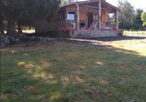 een kleine hut met een grasveld ervoor bij Mi casita de madera in Segovia +5 foto's