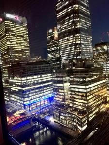a view of a city at night with tall buildings at Stylish 2BRM with nice city view in London