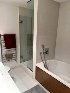 a bathroom with a tub and a shower and a toilet at Stylish 2BRM with nice city view in London