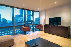 a living room with a flat screen tv and a large window at Stylish 2BRM with nice city view in London