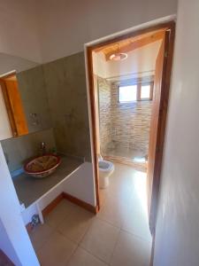 y baño con aseo, lavabo y espejo. en Cabaña El Churqui en Tafí del Valle