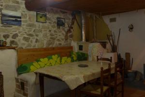 una mesa y sillas en una habitación con una pared de piedra en ecogite Estien, en Boussenac