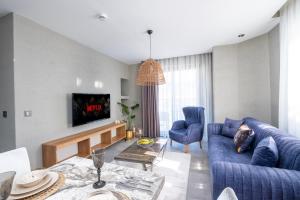 a living room with a blue couch and a tv at Wolf Suites in Antalya