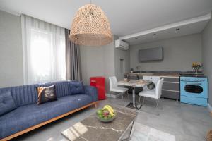 a living room with a blue couch and a kitchen at Wolf Suites in Antalya