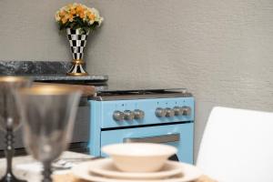 a kitchen with a blue stove and a table with chairs at Wolf Suites in Antalya