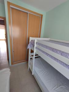 a bunk bed in a room with a door at Apartamento Ático Laguna Beach Almerimar in Almería
