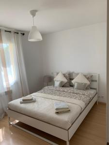 een witte slaapkamer met een groot bed met kussens bij Belle maison de vacance avec piscine in Ménesplet