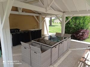 een pergola met een buitenkeuken in een achtertuin bij Belle maison de vacance avec piscine in Ménesplet