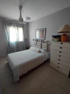 a bedroom with a bed and a dresser and window at Apartamento Ático Laguna Beach Almerimar in Almería