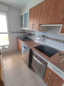 a kitchen with a sink and a stove top oven at Apartamento Ático Laguna Beach Almerimar in Almería