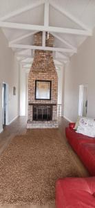 a living room with a brick fireplace with a red couch at Sunbay in Hentiesbaai